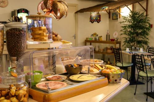 a buffet with a lot of food on a table at Hôtel Le Kolibri in Tournus