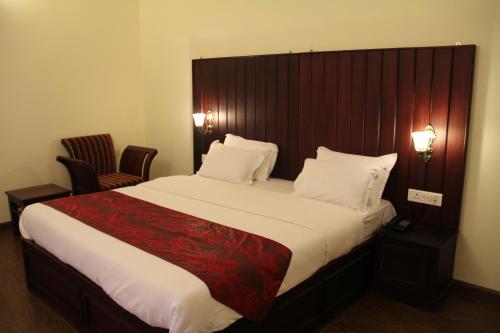 a bedroom with a large bed with a wooden headboard at Golden Springs in Ooty