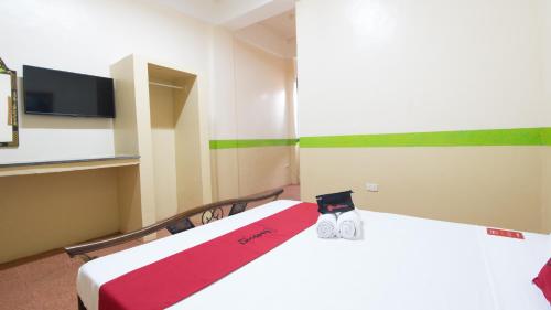 a room with two beds with a red blanket at RedDoorz at Praferosa Resort Hotel Calamba in Calamba