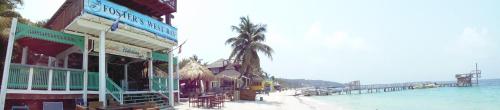 a building on the beach next to the water at Fosters West Bay Resort in West Bay