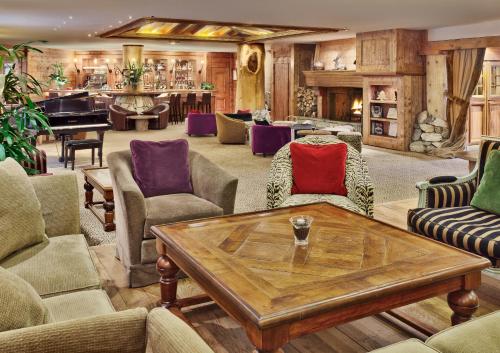 a living room with a table and a piano at Hôtel Les Barmes De l'Ours in Val-d'Isère