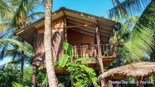 une cabane dans les arbres au milieu de palmiers dans l'établissement Passion Ray Villa & Tree Hut, à Sigirîya