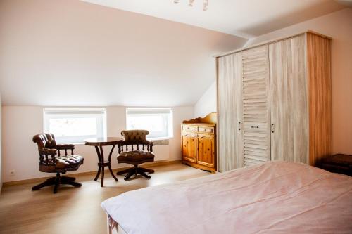 ein Schlafzimmer mit einem Bett und einem Tisch und zwei Stühlen in der Unterkunft Pine Tree in Herbeumont