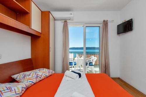 a bedroom with a bed and a view of the ocean at Apartments Ferdo in Živogošće