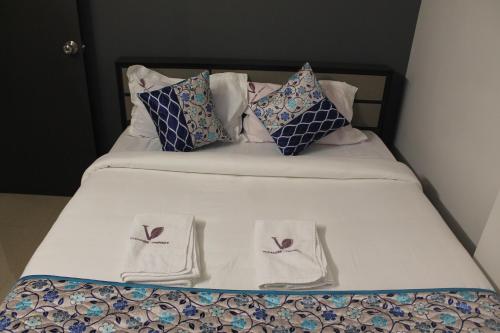 a bed with two towels and pillows on it at Viswa Residency by Azalea in Madurai