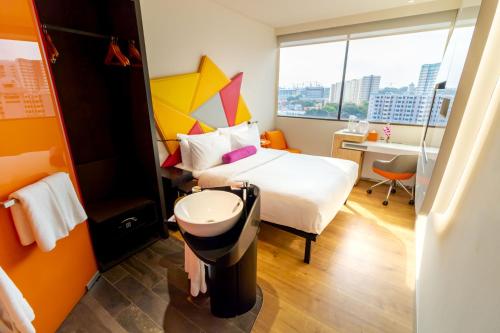 a room with a bed and a sink and a desk at Ibis Styles Singapore On Macpherson in Singapore