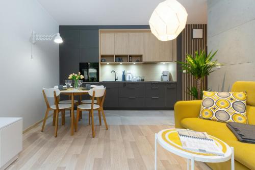- un salon avec un canapé jaune et une table dans l'établissement Apartments Front Park Sadowa by Renters, à Gdańsk