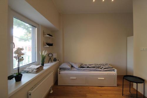 a small bedroom with a bed and a window at El Castillo Apartments in Tallinn