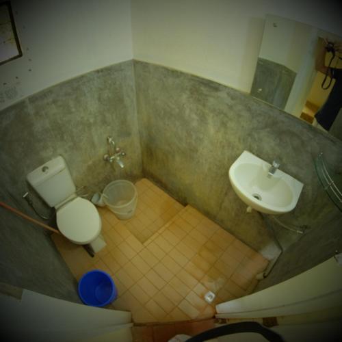 a bathroom with a toilet and a sink at New Creation Guest House in Auroville