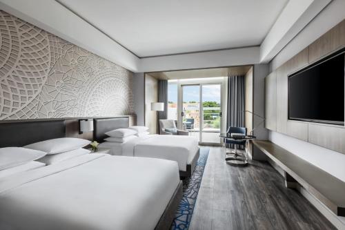 a hotel room with two beds and a flat screen tv at Clark Marriott Hotel in Clark