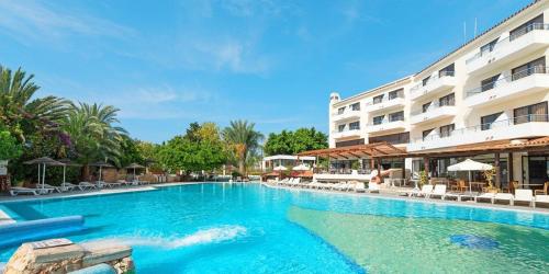 a large swimming pool in front of a hotel at 2 bedroom townhouse, close to Paphos harbour, use of onsite facilities in Paphos