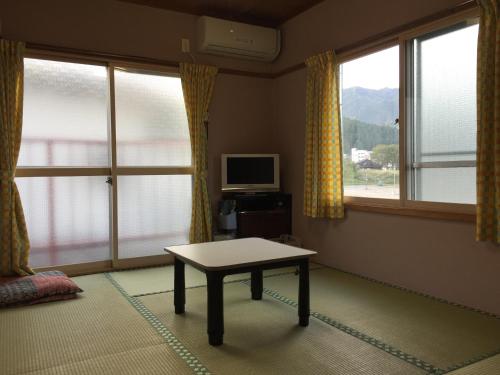 uma sala de estar com uma mesa em frente às janelas em Mistral em Minami Uonuma