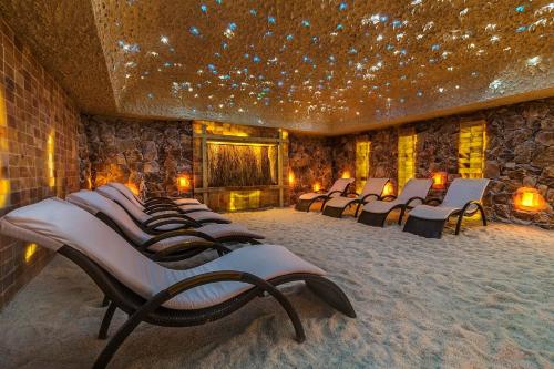 a row of chairs in a room with a stone wall at Grand Lubicz Uzdrowisko Ustka in Ustka