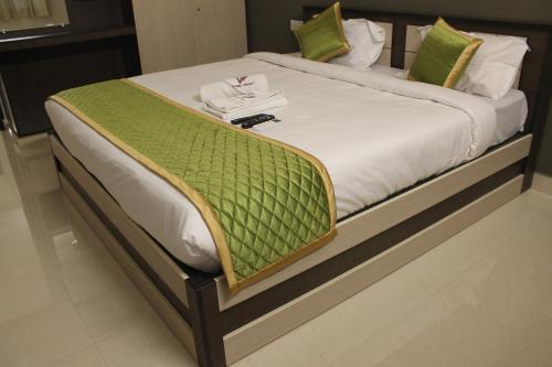 Viswa Residency by Azalea tesisinde bir odada yatak veya yataklar