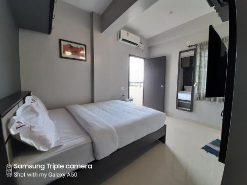 a bedroom with a large white bed in a room at Viswa Residency by Azalea in Madurai