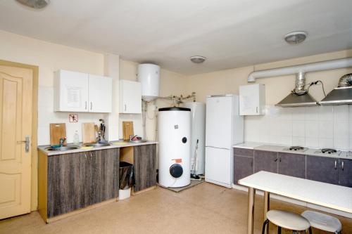 a kitchen with white appliances and a table and chairs at Podolski Parus in Kyiv