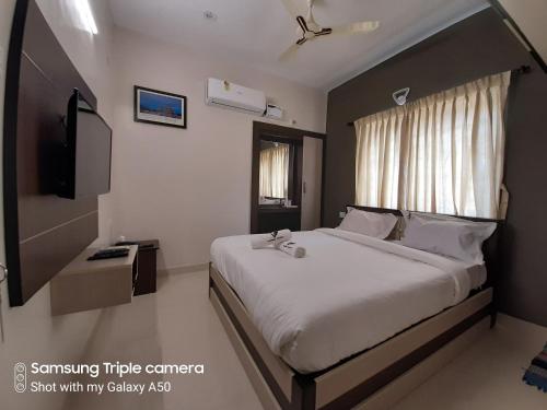 a bedroom with a large bed and a window at Viswa Residency by Azalea in Madurai