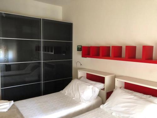 twee bedden in een kleine kamer met rode planken bij Casa Al Poggetto in Florence