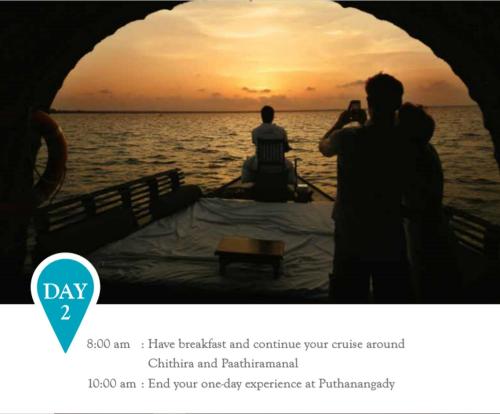 two people taking a picture of the sunset on a boat at Spice Coast Cruises - Houseboat, A CGH Earth Experience in Alleppey