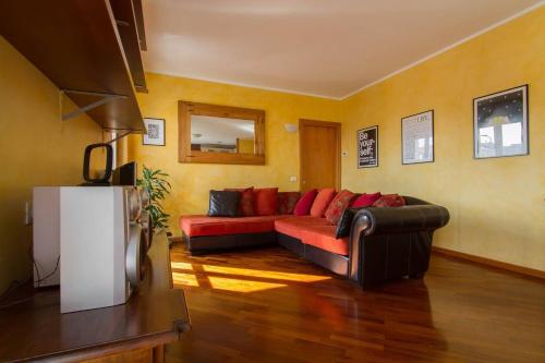 - un salon avec un canapé rouge et des murs jaunes dans l'établissement Bright house with 2 bedrooms & a unique terrace, à Bergame