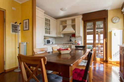 une cuisine avec une grande table et des chaises en bois dans l'établissement Bright house with 2 bedrooms & a unique terrace, à Bergame