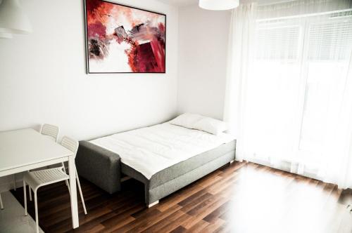 a bedroom with a bed and a painting on the wall at Apartament Rosso in Łódź