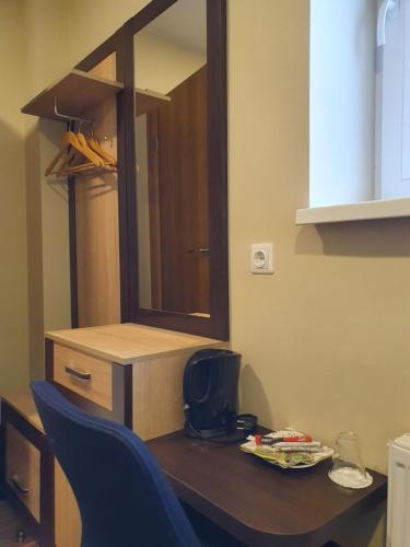 a table with a mirror and a blue chair at Šolena in Alytus