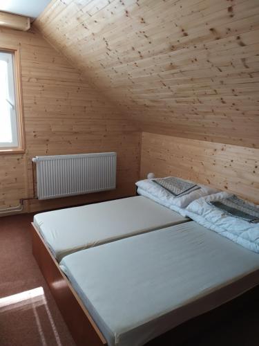 a bedroom with two beds in a wooden room at Apartmany Bobule in Deštné v Orlických horách