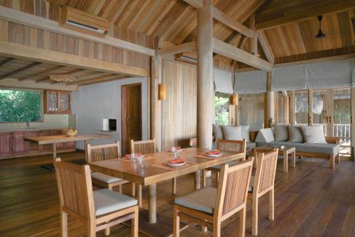 a dining room with a table and chairs and a couch at Six Senses Ninh Van Bay in Ninh Van Bay
