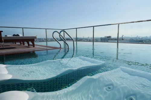 a hot tub on the roof of a building at Sofiana My Khe Hotel & Spa- Rooftop Pool Bar in Danang