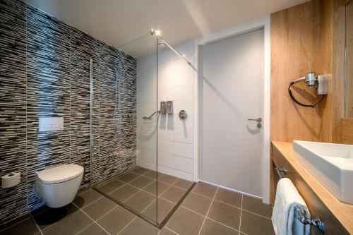 een badkamer met een douche, een toilet en een wastafel bij Hotel 46 in Wintelre