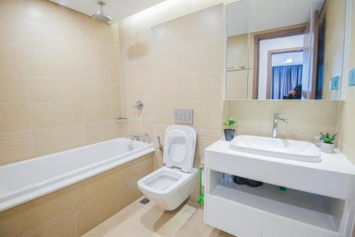 a bathroom with a sink and a toilet and a bath tub at Vinhomes Metropolis luxury Hotel & Residence in Hanoi