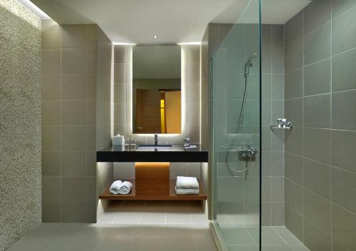 a bathroom with a sink and a glass shower at Manado Tateli Resort and Convention in Manado