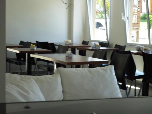 an empty restaurant with tables and chairs with pillows at Ayres Sur in Mar del Plata