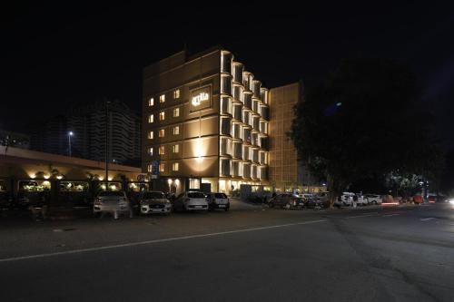 a building with cars parked in front of it at night at Artilla Inn in Ahmedabad