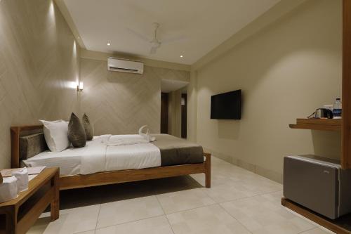 a bedroom with a bed and a television in it at Artilla Inn in Ahmedabad