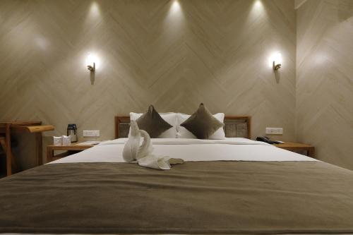 a bedroom with a bed with a stuffed animal on it at Artilla Inn in Ahmedabad