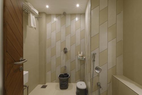 a bathroom with a shower with a toilet and a sink at Artilla Inn in Ahmedabad