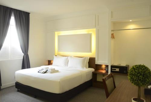 馬六甲的住宿－碧蘭精品酒店，酒店客房配有一张床铺和一张桌子。