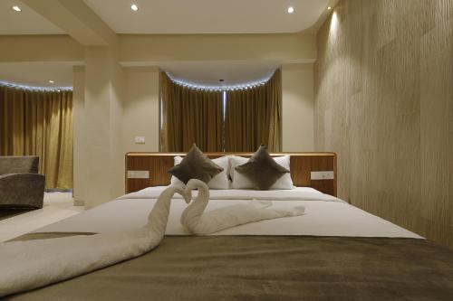 a bedroom with a large bed with swans on it at Artilla Inn in Ahmedabad