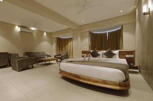 a bedroom with a large bed and a living room at Artilla Inn in Ahmedabad