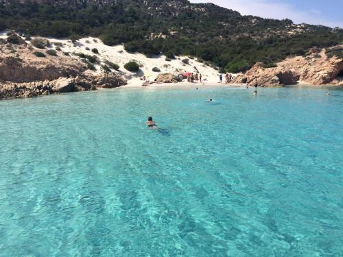 a person swimming in a large body of water at Hotel Villa Del Parco in La Maddalena