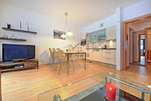 a living room with a table and chairs and a tv at St. Peter Apartment in Špindlerův Mlýn