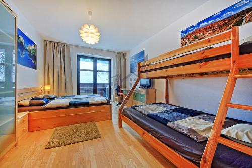 a bedroom with two bunk beds and a window at St. Peter Apartment in Špindlerův Mlýn