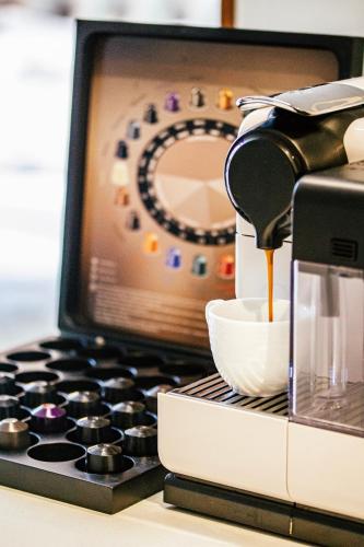 a coffee maker is pouring coffee into a cup at Nicara to Akker Collective in Stellenbosch