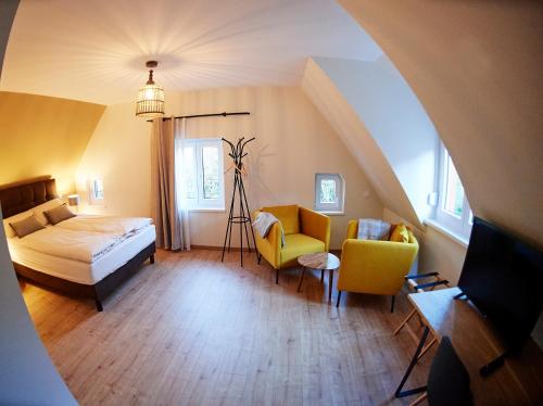 ein Schlafzimmer mit einem Bett und Stühlen in einem Zimmer in der Unterkunft La Forge in Ringendorf