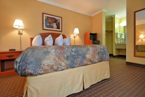 Habitación de hotel con cama grande con almohadas en Americas Best Value Inn Killeen Ft Hood, en Killeen