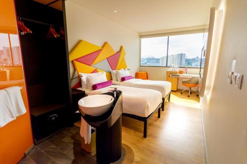 a hotel room with two beds and a sink at Ibis Styles Singapore On Macpherson in Singapore
