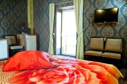 ein Schlafzimmer mit einem Bett mit einer roten Decke und einem Fenster in der Unterkunft Pas Radvila in Kaišiadorys