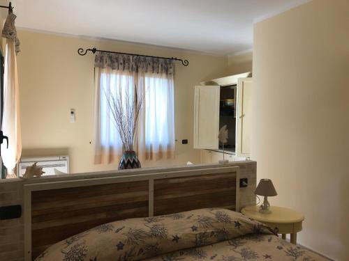 a bedroom with a bed and a window at Hotel Villa Del Parco in La Maddalena
